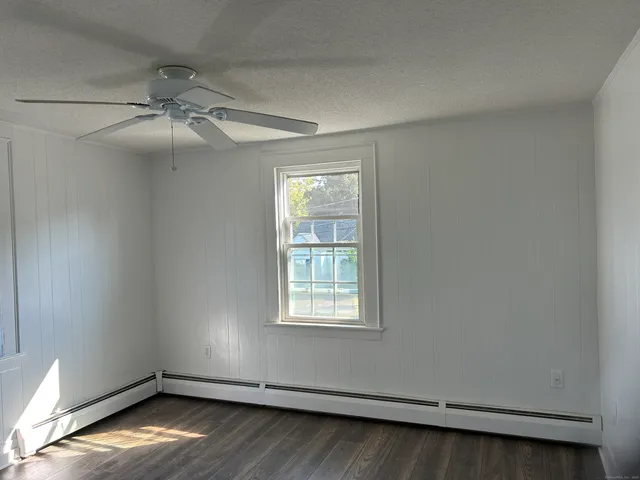 an empty room with a window and wooden floor