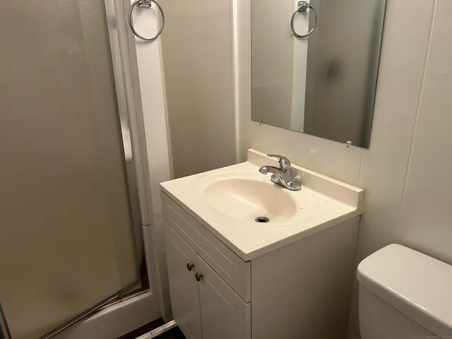 a bathroom with a sink mirror vanity and toilet