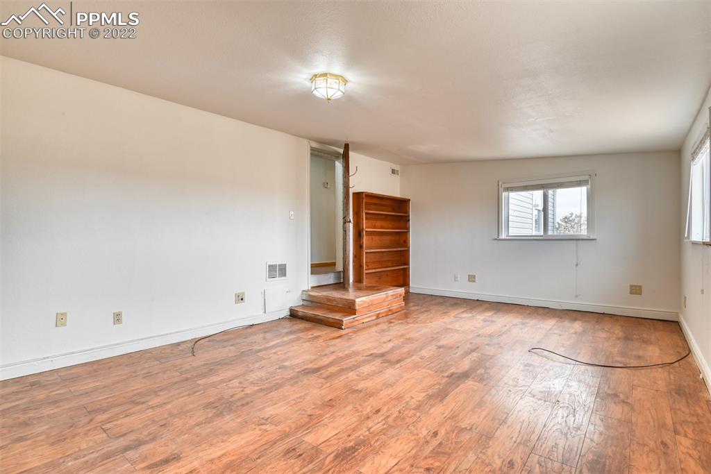 6175 Mulberry Road Calhan, CO 80808 - Photo 29 of 46 an empty room with wooden floor and windows