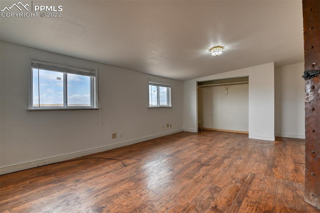 6175 Mulberry Road Calhan, CO 80808 - Photo 31 of 46 an empty room with wooden floor and windows