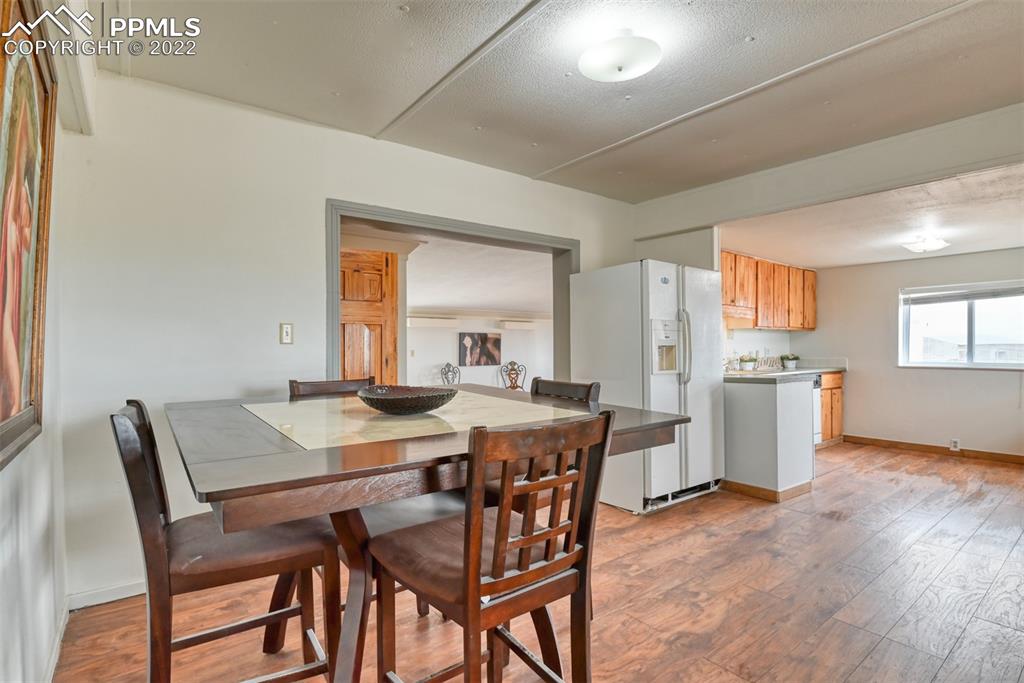 6175 Mulberry Road Calhan, CO 80808 - Photo 34 of 46 a view of a dining room with furniture and wooden floor