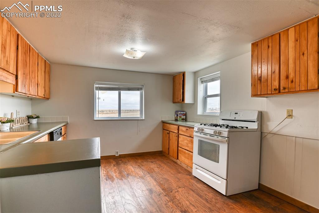 6175 Mulberry Road Calhan, CO 80808 - Photo 37 of 46 a kitchen with stainless steel appliances granite countertop a stove a sink and a refrigerator