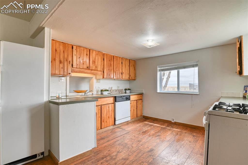 6175 Mulberry Road Calhan, CO 80808 - Photo 38 of 46 a kitchen with stainless steel appliances granite countertop a stove a sink dishwasher and a refrigerator