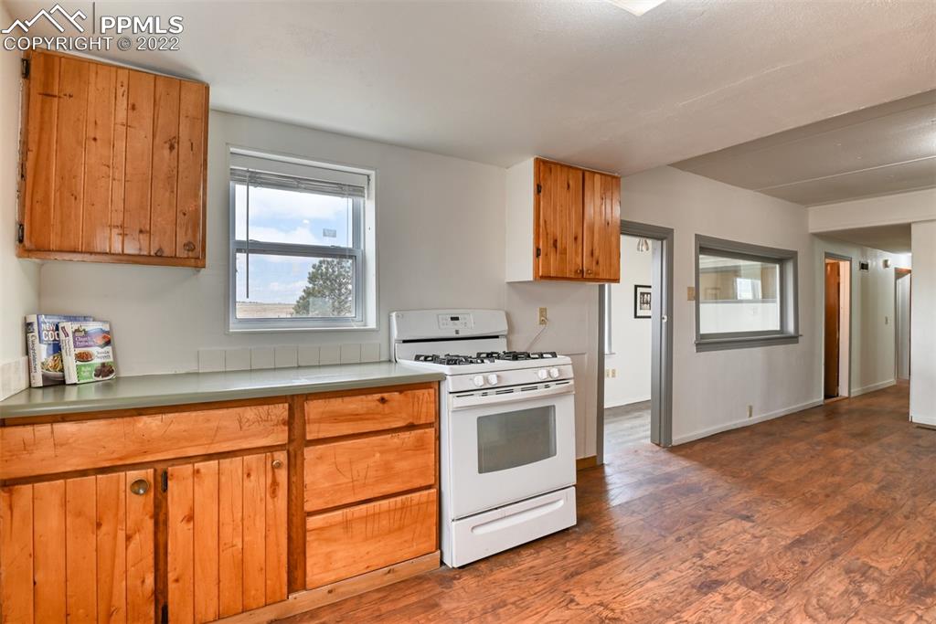 6175 Mulberry Road Calhan, CO 80808 - Photo 40 of 46 a kitchen with granite countertop white cabinets and white appliances