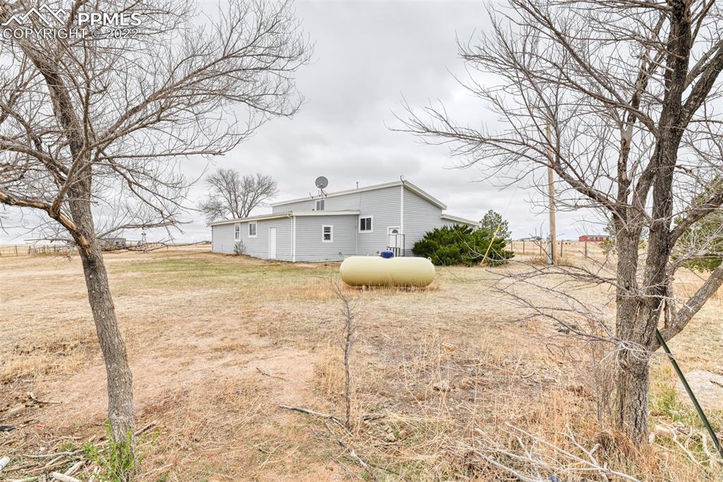 6175 Mulberry Road Calhan, CO 80808 - Photo 7 of 46 a large white house with a large tree in front of it