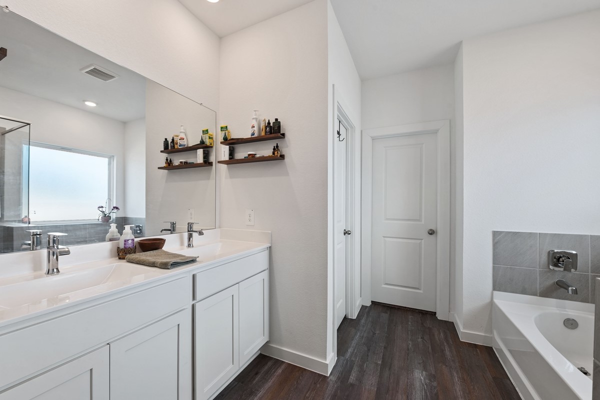 815 Devils Bridge Street Conroe, TX 77303 - Photo 13 of 25 a bathroom with a double vanity sink a mirror and bathtub
