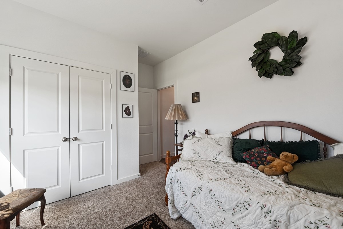 815 Devils Bridge Street Conroe, TX 77303 - Photo 14 of 25 a bedroom with a bed and a chandelier