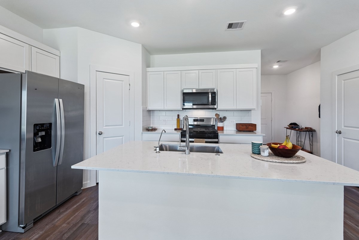 815 Devils Bridge Street Conroe, TX 77303 - Photo 5 of 25 a kitchen with stainless steel appliances a refrigerator sink and microwave