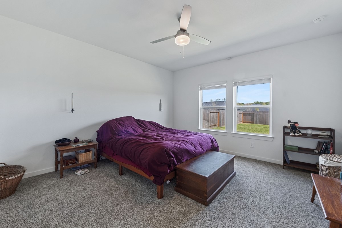 815 Devils Bridge Street Conroe, TX 77303 - Photo 10 of 25 a spacious bedroom with a bed and a chandelier