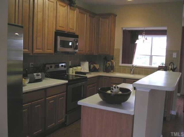145 Deacon Ridge Street Wake Forest, NC 27587 - Photo 3 of 9 a kitchen with a sink stove and cabinets