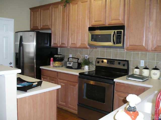 145 Deacon Ridge Street Wake Forest, NC 27587 - Photo 4 of 9 a kitchen with stainless steel appliances a stove a microwave and a refrigerator