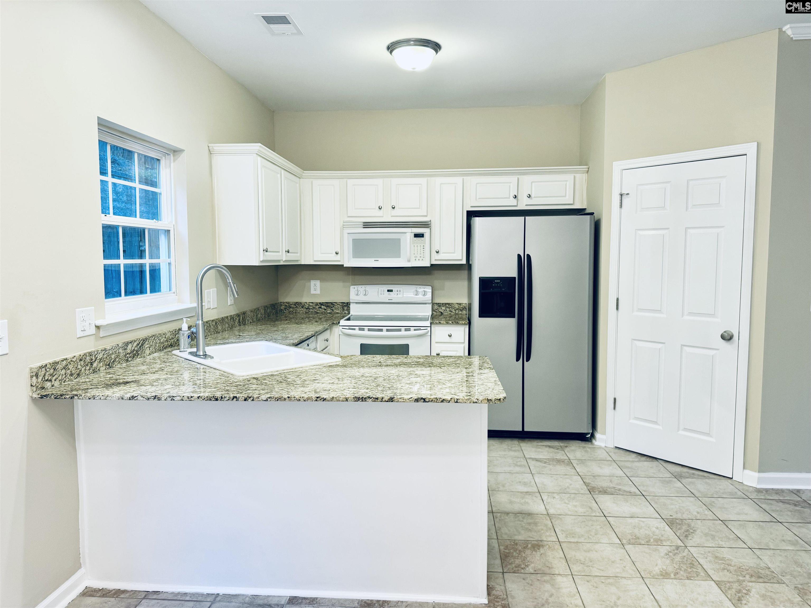 108 Tuscany Court Irmo, SC 29063 - Photo 6 of 13 a kitchen with stainless steel appliances granite countertop a sink refrigerator and cabinets