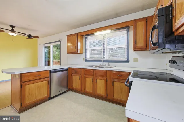 a kitchen with granite countertop a sink stove and cabinets