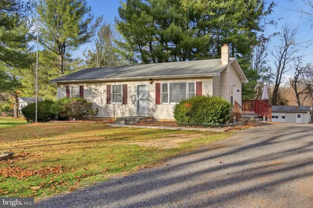 a view of a house with a yard and large trees