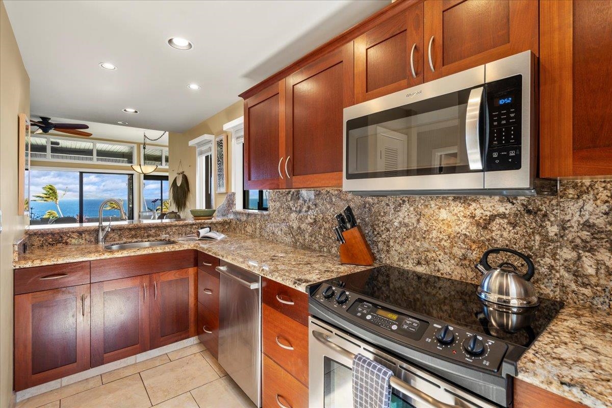 100 Ridge Road, Unit 2915 Lahaina, HI 96761 - Photo 7 of 43 a kitchen with stainless steel appliances granite countertop a stove and a microwave