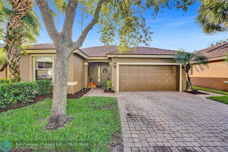 Manicured front yard leads up to private front entrance and beautifully paved driveway.
