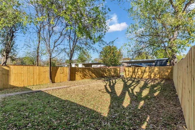 a view of backyard with wooden fence