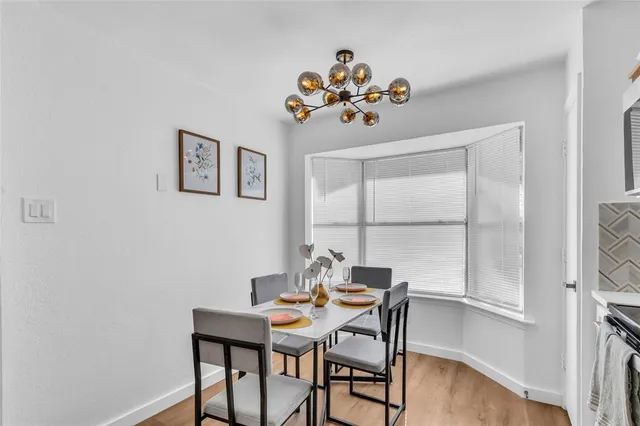 a view of a dining room with furniture a chandelier and wooden floor