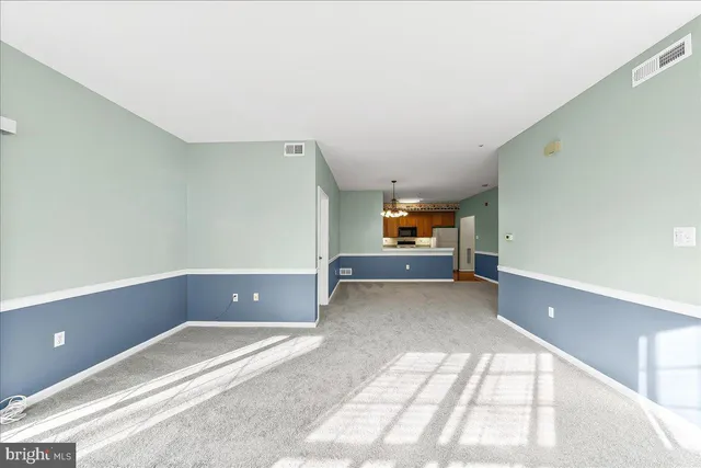 a view of a room with a chandelier and a kitchen