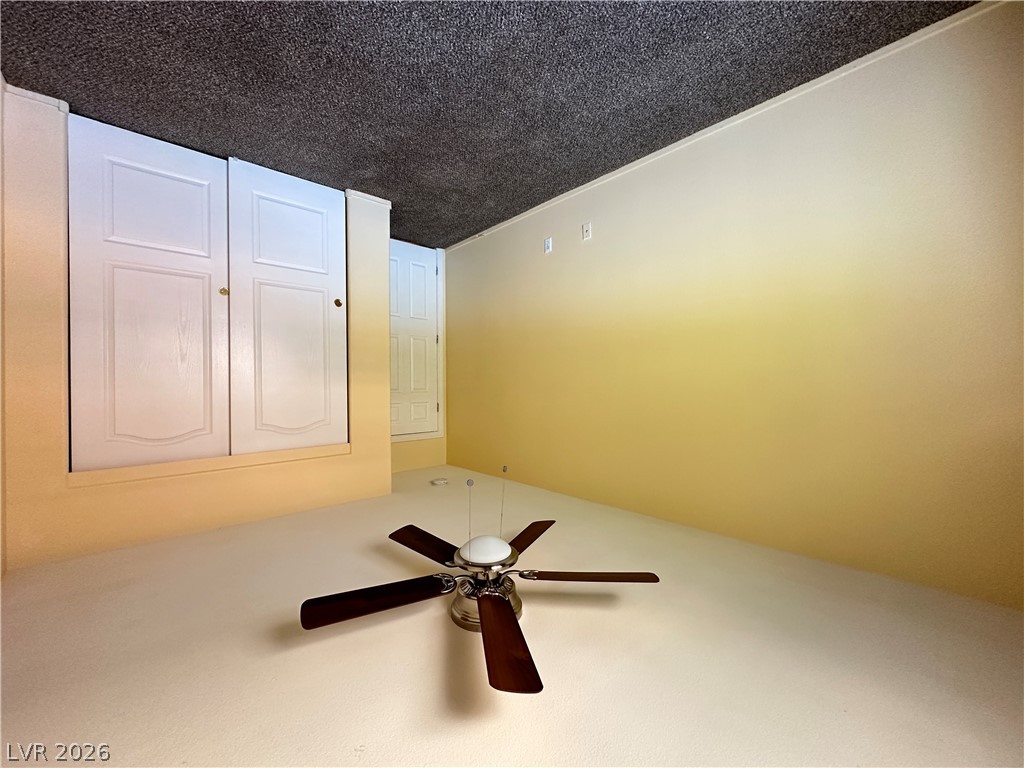 9032 Rutherford Grove Street Las Vegas, NV 89148 - Photo 12 of 24 Functional room features a ceiling fan, closet space, and a neutral palette, ready for personalization.