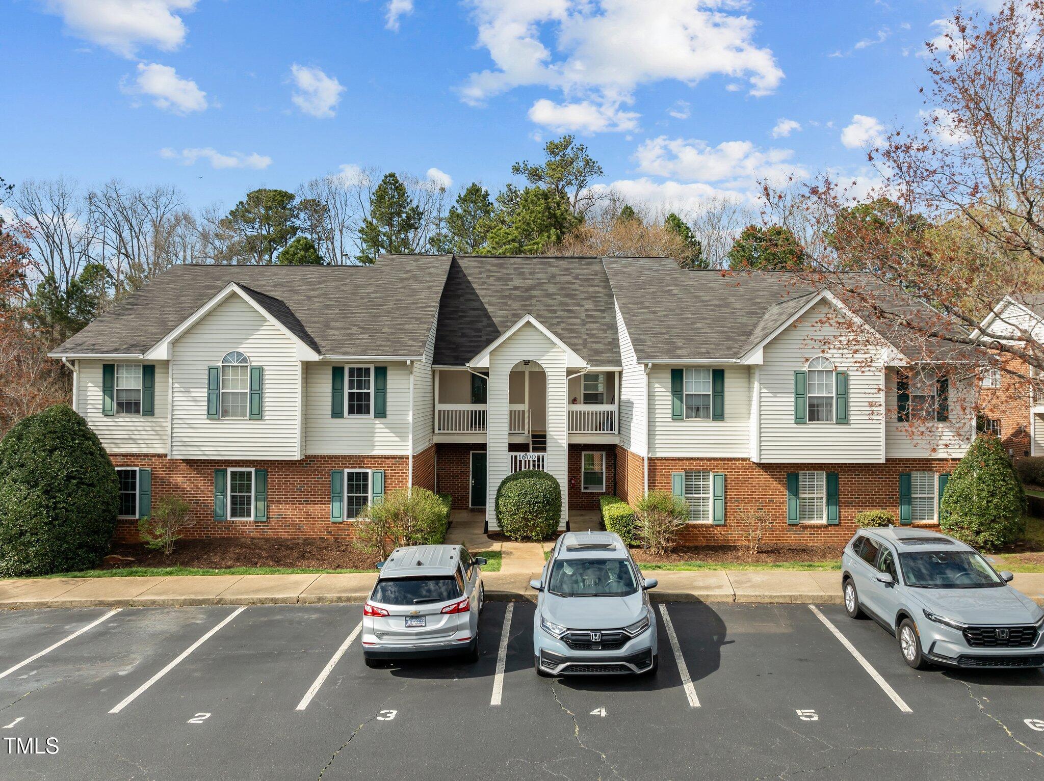 1613 Bulon Drive Cary, NC 27518 - Photo 17 of 26 a view of a white house with a large space and a car parked in front of it