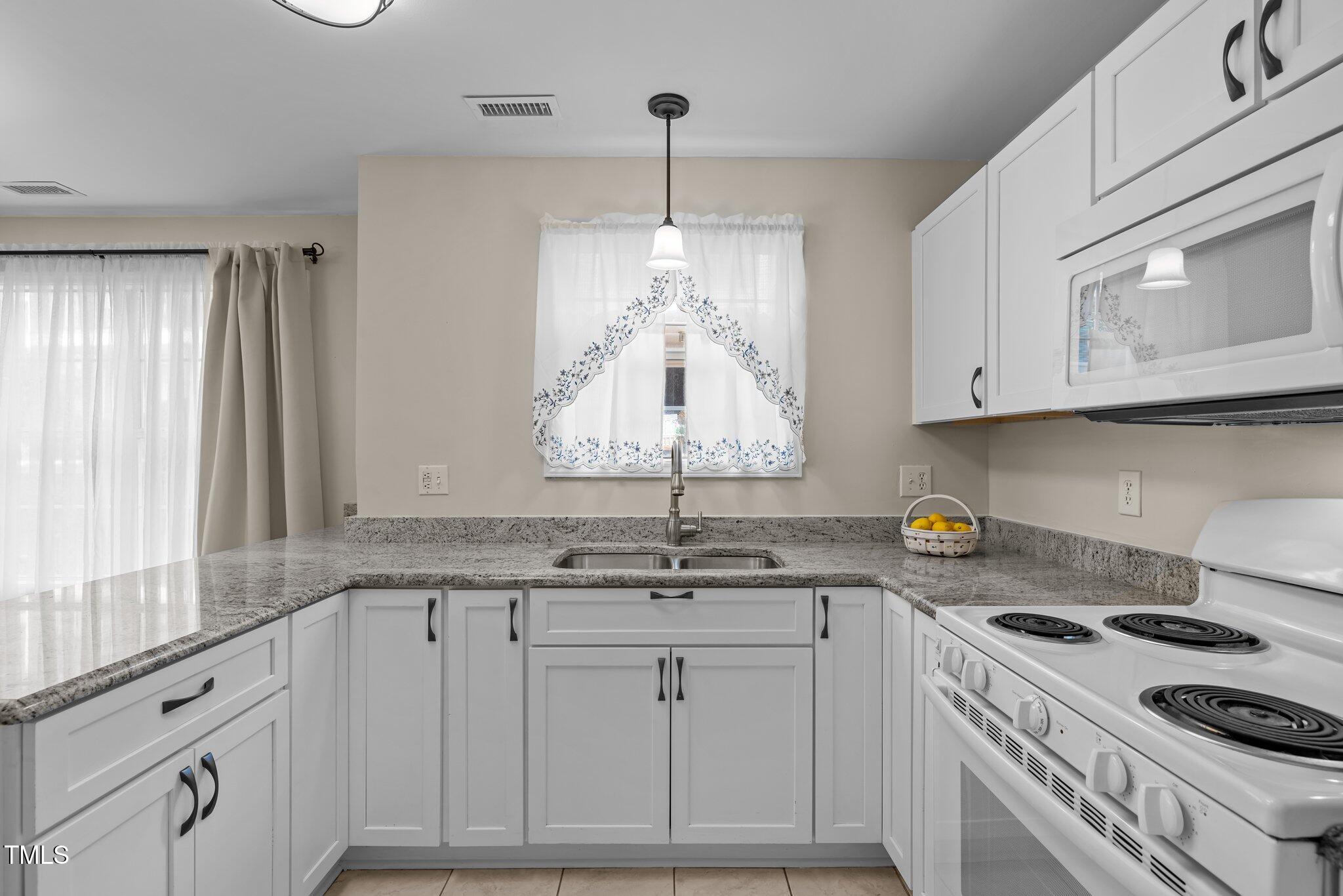 1613 Bulon Drive Cary, NC 27518 - Photo 4 of 26 a kitchen with granite countertop white cabinets and a stove