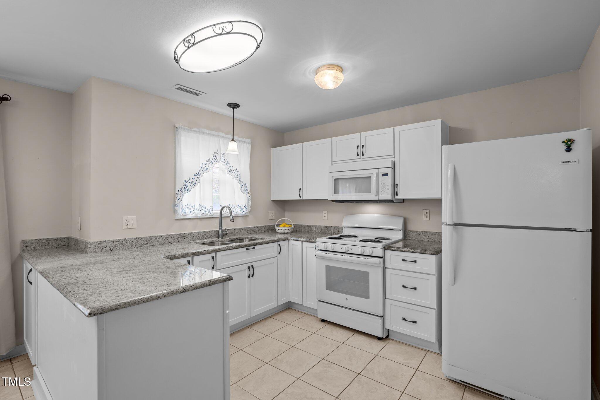 1613 Bulon Drive Cary, NC 27518 - Photo 5 of 26 a kitchen with stainless steel appliances granite countertop a sink stove and refrigerator