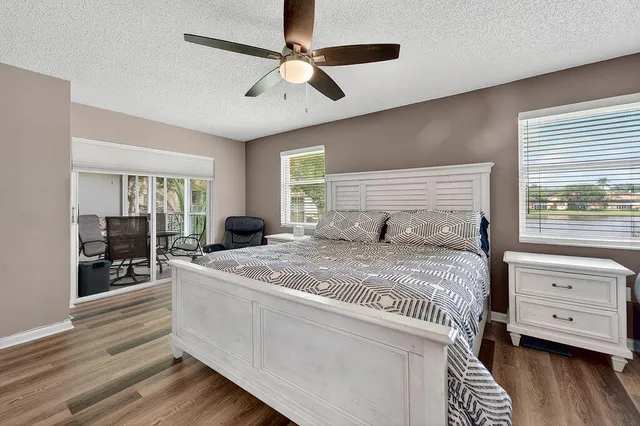 a kitchen with a sink and white cabinets with wooden floor