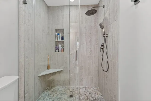 a bathroom with a sink a toilet a mirror and shower curtain