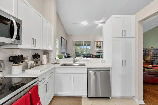 a kitchen with white cabinets and appliances