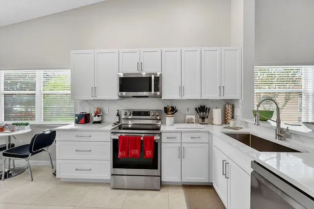 a kitchen with cabinets appliances a sink and a window