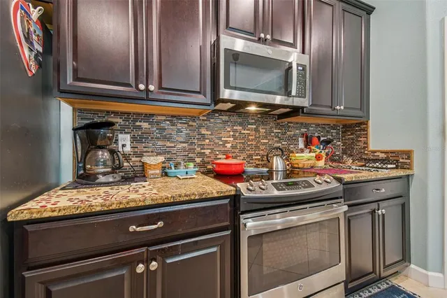a kitchen with stainless steel appliances granite countertop a sink stove and microwave