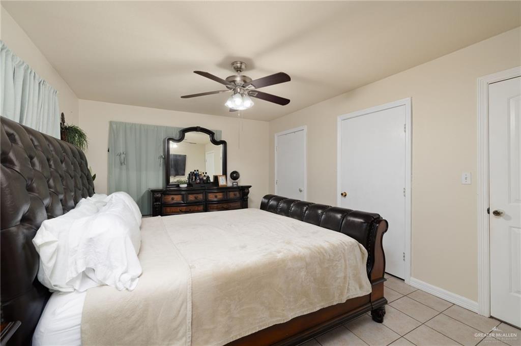 1222 South Bluebonnet Street Pharr, TX 78577 - Photo 9 of 17 a bedroom with a bed and a chandelier