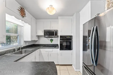 a kitchen with stainless steel appliances a refrigerator sink and microwave
