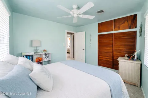 a bedroom with a bed and a ceiling fan