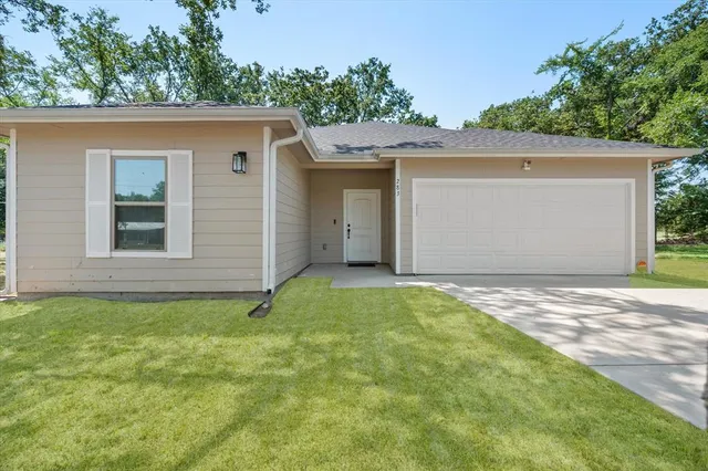 a front view of a house with a yard and garage