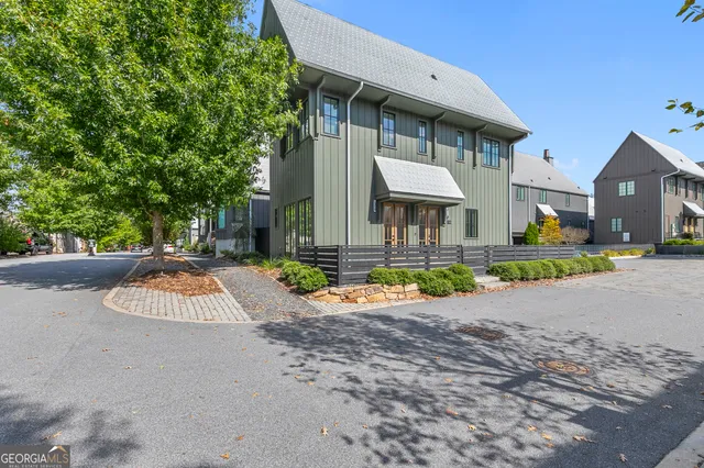 a view of a house with a yard and table and chairs under an umbrella