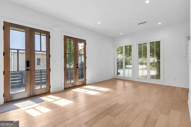 a view of an empty room with glass door and balcony