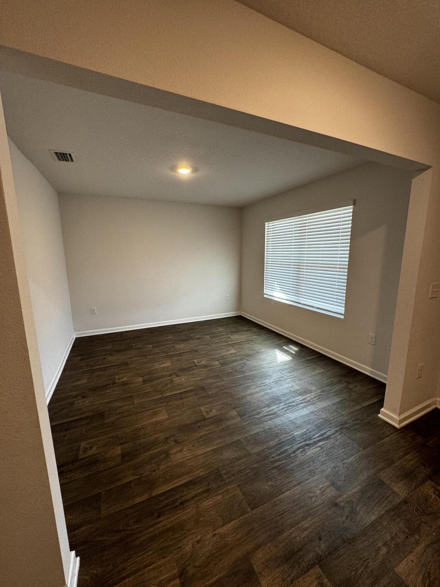 5444 Merlin Way Milton, FL 32583 - Photo 3 of 20 an empty room with wooden floor and windows