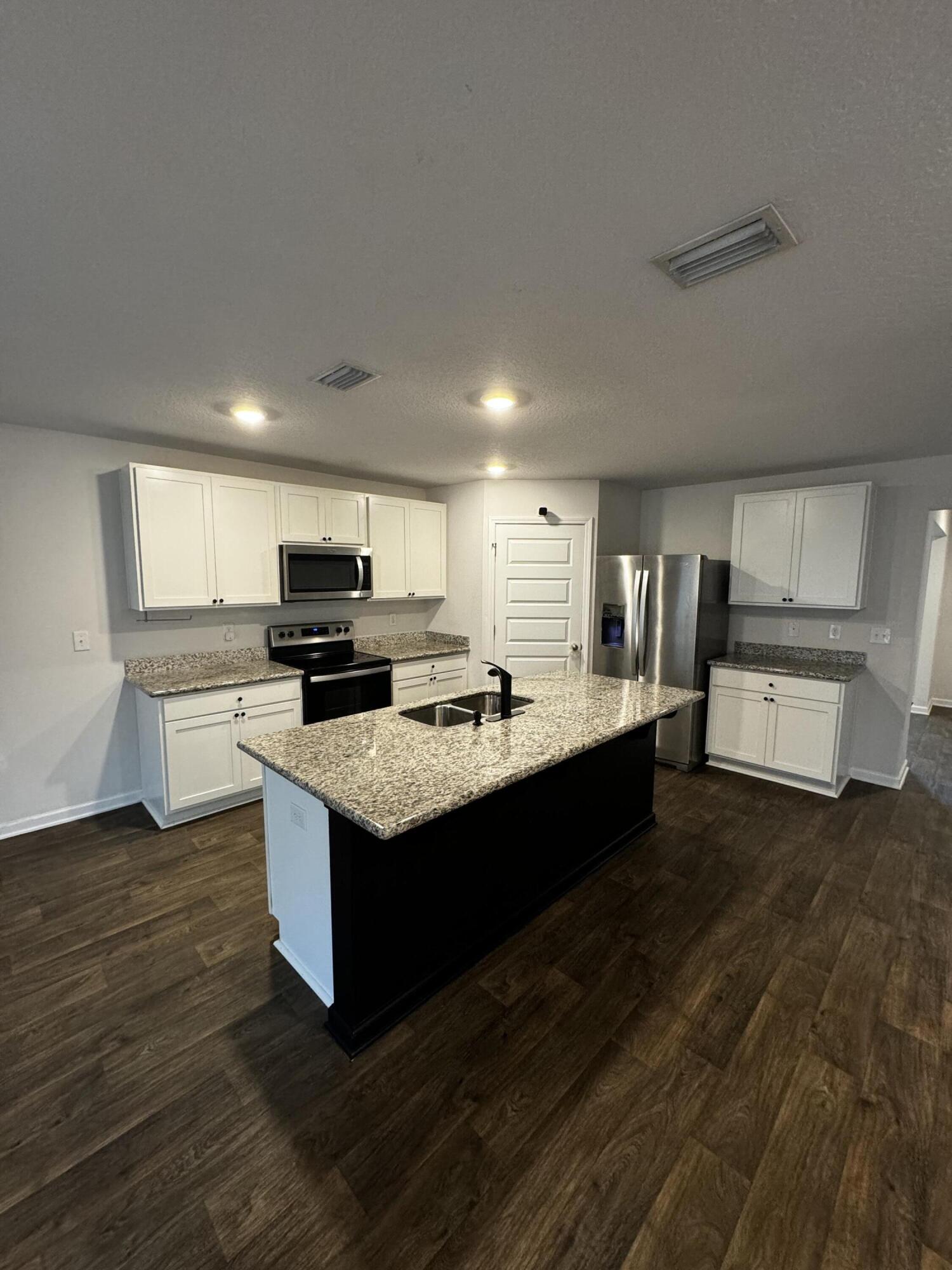 5444 Merlin Way Milton, FL 32583 - Photo 5 of 20 a large kitchen with stainless steel appliances kitchen island granite countertop a large counter top and a stove