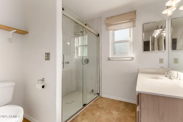 a bathroom with a sink a toilet and shower