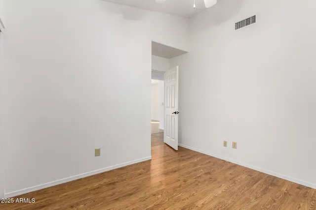 a view of empty room with wooden floor