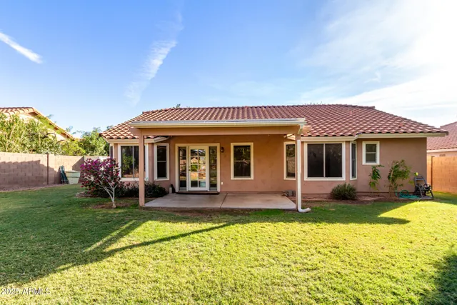 a view of a house with a yard patio and fire pit