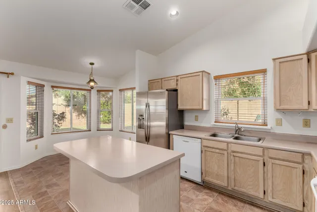 a kitchen with white cabinets and window