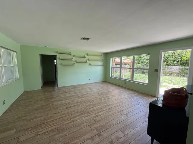 wooden floor in an empty room with a window