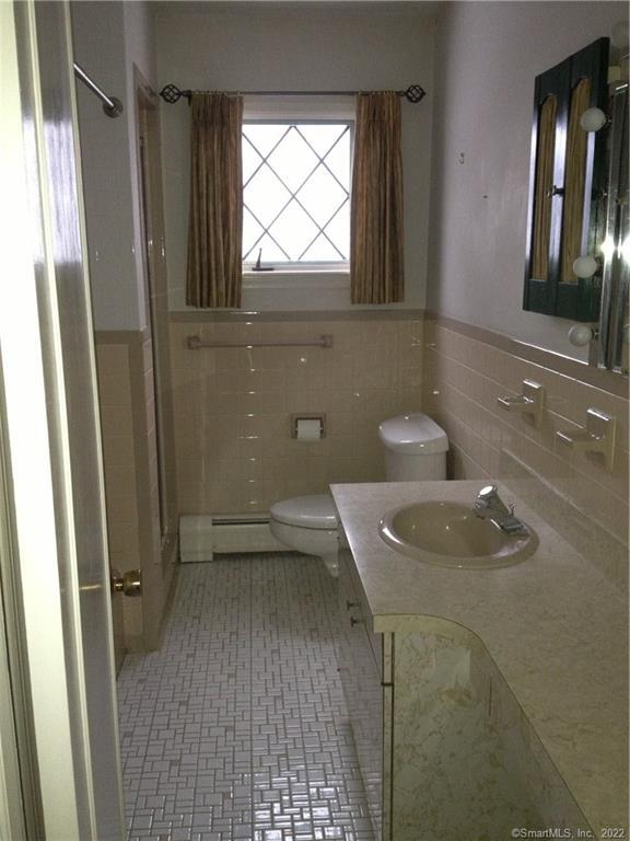 927 Burroughs Road Fairfield, CT 06825 - Photo 17 of 33 a bathroom with a sink a toilet a mirror and window