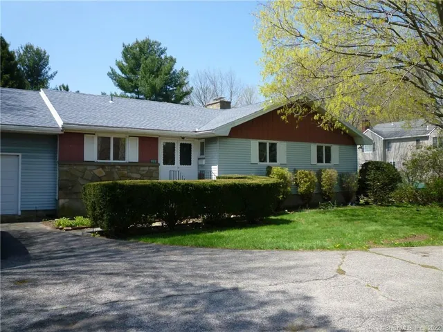 a front view of a house with a yard and a garden