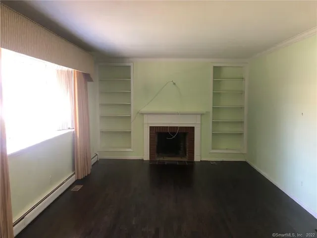 an empty room with a fireplace and windows
