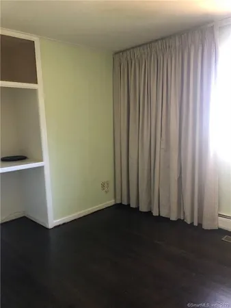 a view of a room with wooden floor
