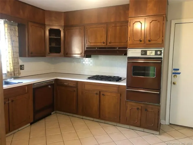 a kitchen with stainless steel appliances granite countertop a sink and a stove